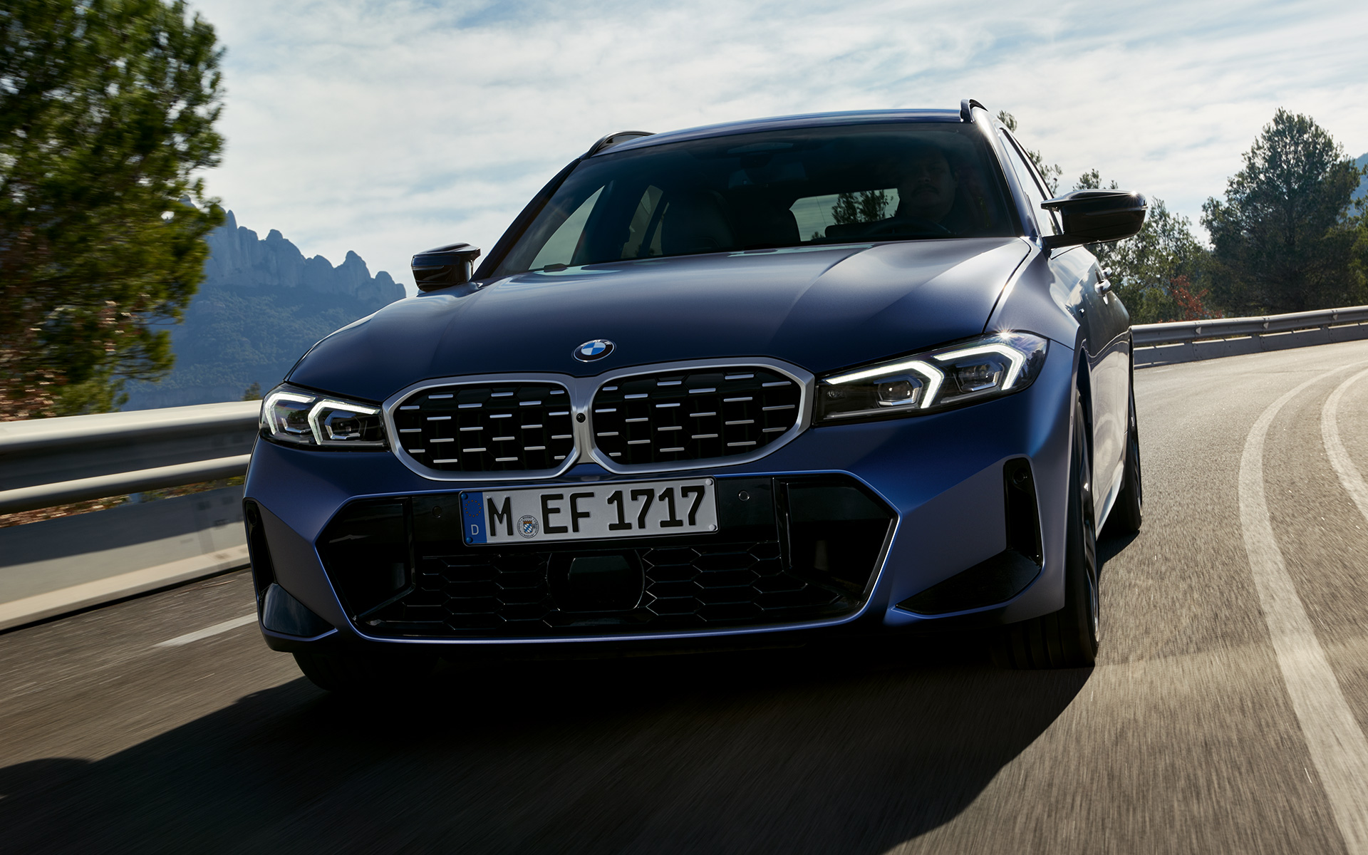 BMW M340i xDrive Touring G21 Frozen Tanzanite Blue, vue avant en mouvement sur la route