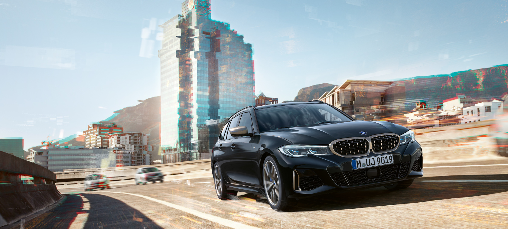 Vue de trois quarts avant dans un décor urbain G21 BMW M340i xDrive Touring, vue de trois quarts avant dans un décor urbain G21