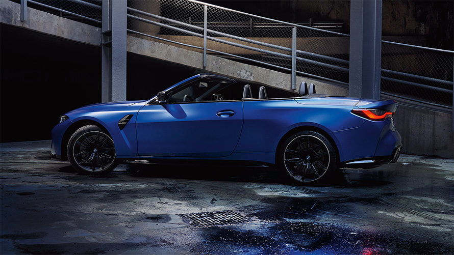 BMW M4 Competition Cabrio met M xDrive G83 2021 zijaanzicht met geopende kap BMW M4 Competition Cabrio met M xDrive G83 2021 Frozen Portimao Blau metallic zijaanzicht met geopende kap