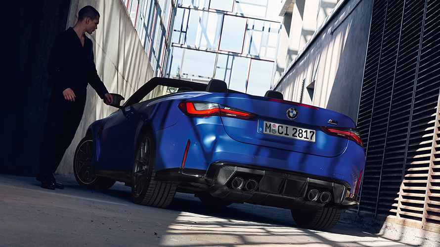 BMW M4 Competition Cabrio met M xDrive G83 2021 driekwart achteraanzicht BMW M4 Competition Cabrio met M xDrive G83 2021 BMW Individual Frozen Portimao Blau metallic driekwart achteraanzicht met man