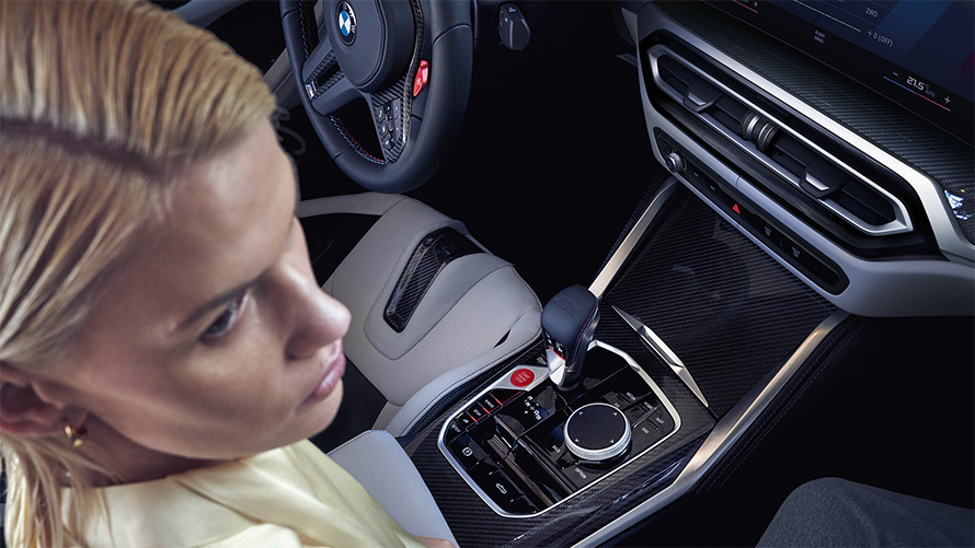 BMW M4 Competition Cabrio met M xDrive G83 interieur 2021 middenconsole BMW M4 Competition Cabrio met M xDrive G83 2021 middenconsole en vrouw op passagierszetel