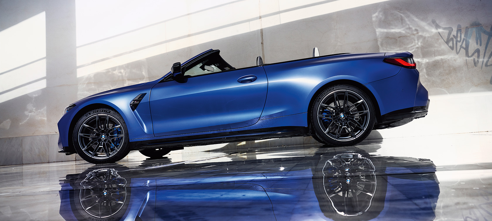 BMW M4 Competition Cabrio met M xDrive G83 2021 driekwart vooraanzicht rijdend BMW M4 Competition Cabrio met M xDrive G83 2021 BMW Individual Frozen Portimao Blau metallic driekwart vooraanzicht rijdend