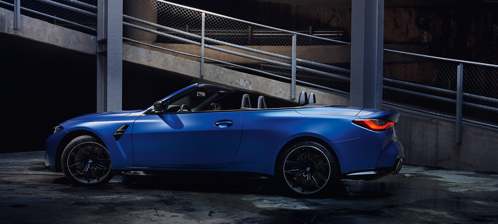 BMW M4 Competition Cabrio met M xDrive G83 2021 zijaanzicht stilstaand BMW M4 Competition Cabrio met M xDrive G83 2021 BMW Individual Frozen Portimao Blau metallic zijaanzicht stilstaand