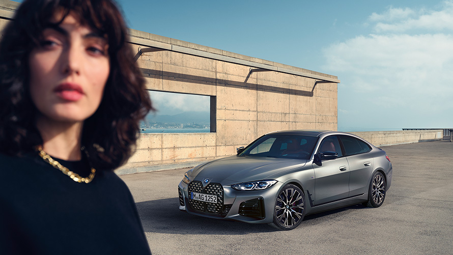 BMW M440i xDrive Gran Coupé G26 2021 driekwart vooraanzicht met model BMW M440i xDrive Gran Coupé G26 2021 Frozen Pure Grey metallic driekwart vooraanzicht met model