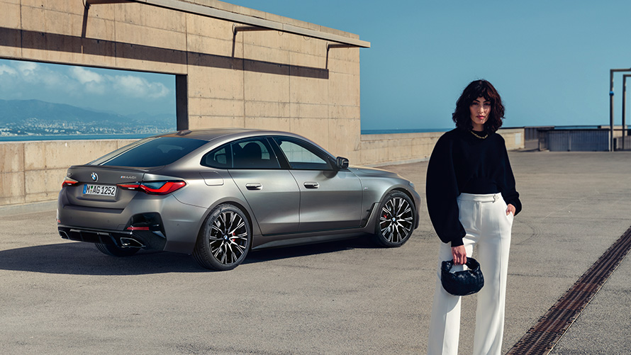 BMW M440i xDrive Gran Coupé G26 2021 driekwart achteraanzicht met model BMW M440i xDrive Gran Coupé G26 2021 driekwart achteraanzicht met model