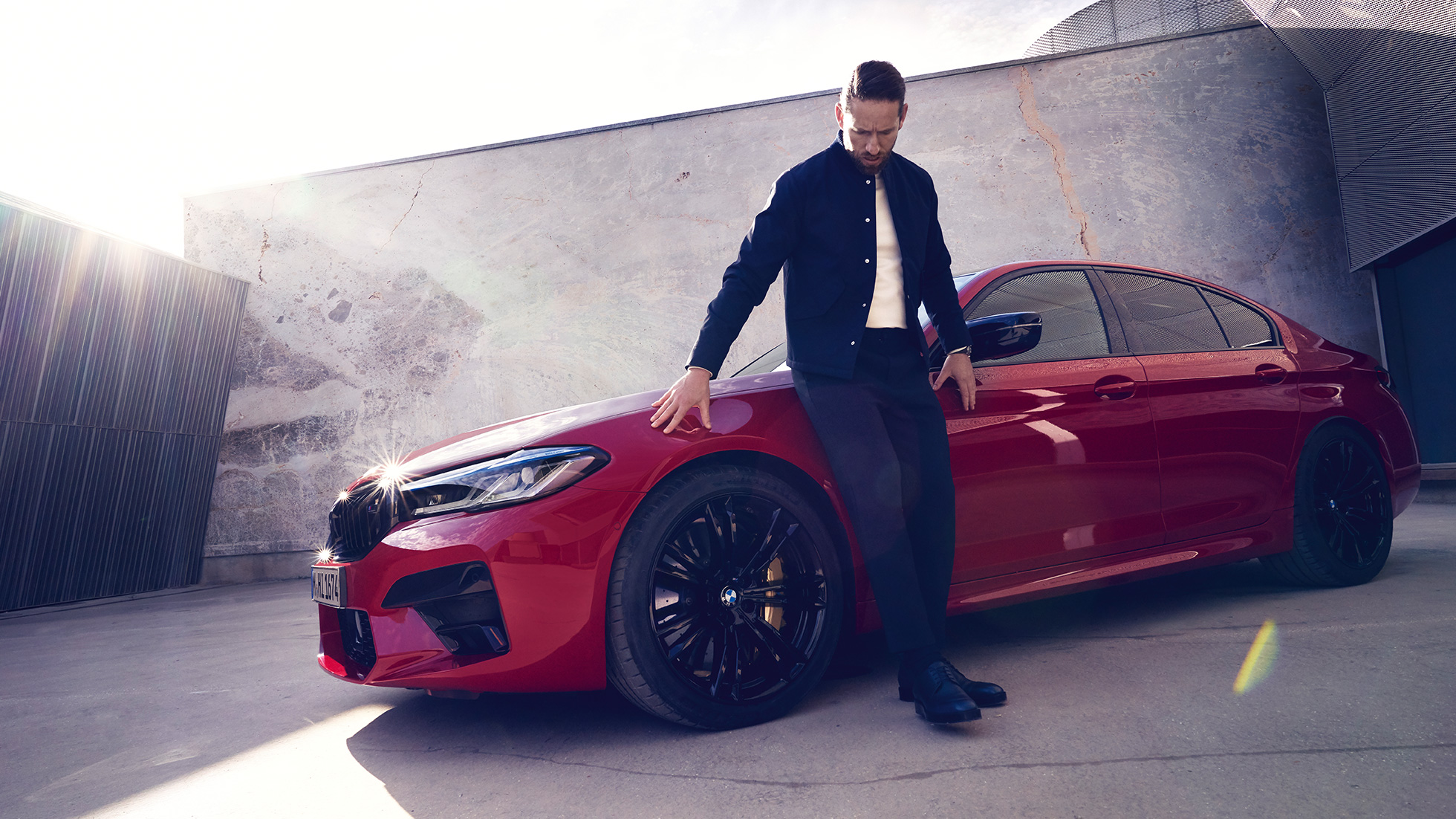 BMW M5 Competition F90 LCI facelift 2020 zijaanzicht met man BMW M5 Competition F90 LCI facelift 2020 BMW Individual Imola Rot zijaanzicht met man