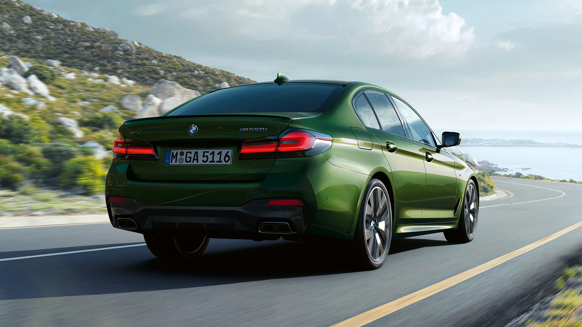 BMW M550i xDrive Berline G30 LCI facelift 2020 achteraanzicht BMW M550i xDrive Berline G30 LCI facelift 2020 BMW Individual Verde Ermes metallic achteraanzicht rijdend op landweg