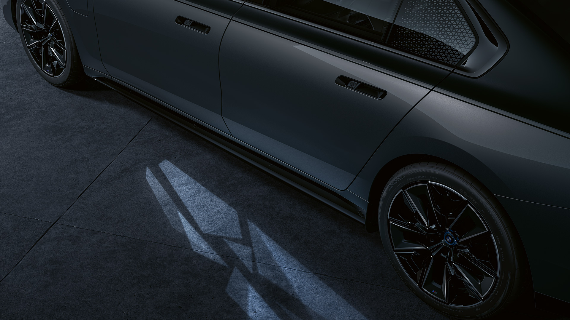 Lichtconcept BMW M760e xDrive G70 Lichtconcept BMW M760e xDrive G70 two-tone koetswerkkleur Saphirschwarz metallic BMW Individual Dravitgrau metallic zijdelingse close-up met ingeschakeld Welcome Light Carpet