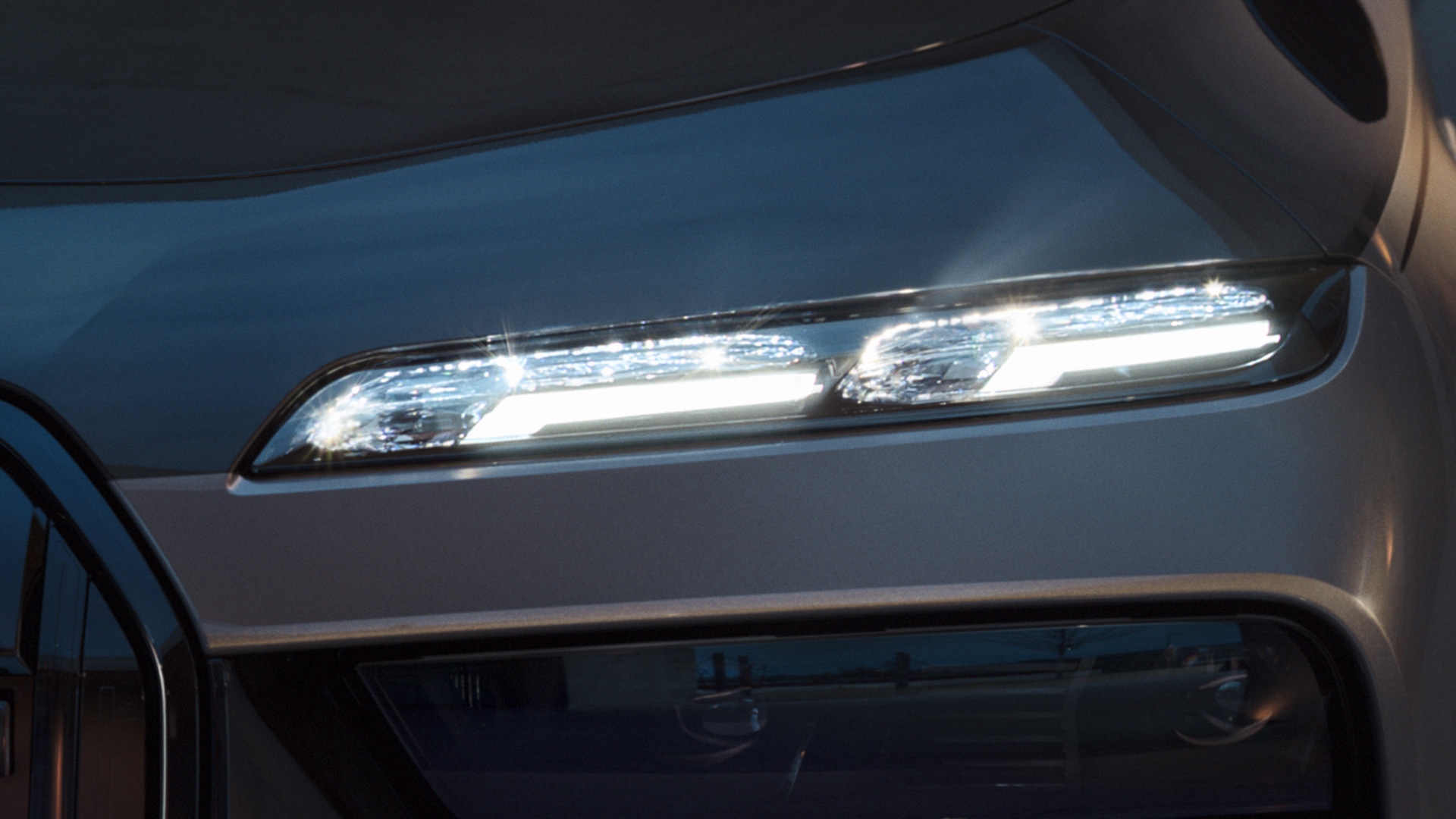 BMW kristallen koplampen Iconic Glow BMW M760e xDrive G70 BMW kristallen koplampen Iconic Glow BMW M760e xDrive G70 BMW Individual two-tone koetswerkkleur Saphirschwarz metallic BMW Individual Dravitgrau metallic close-up met ingeschakelde verlichting