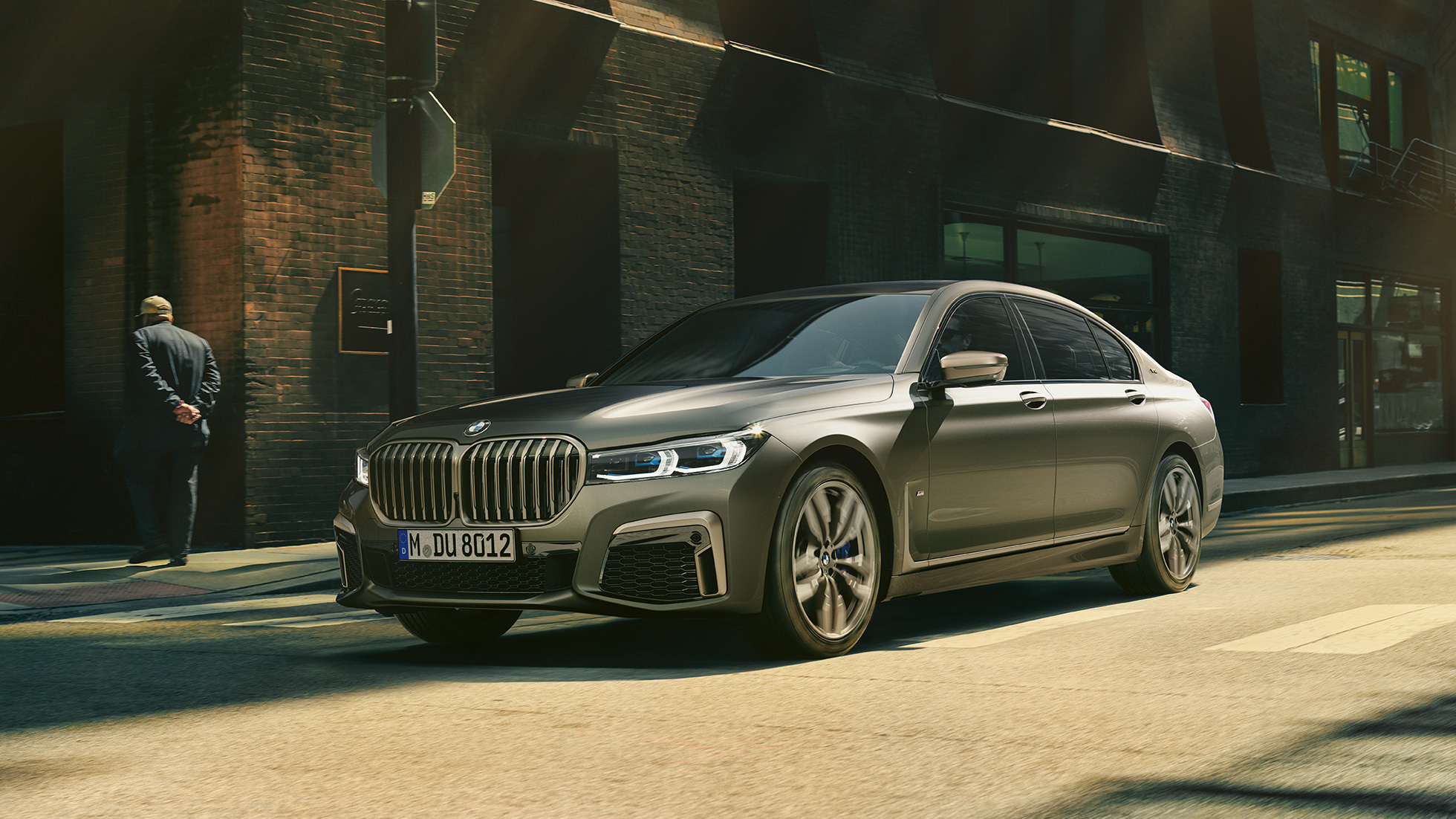BMW M760Li xDrive Berline dans un décor urbain G11 BMW M760Li xDrive Berline, se déplaçant sur une route dans un décor urbain, vue de profil de la partie avant du véhicule G11.