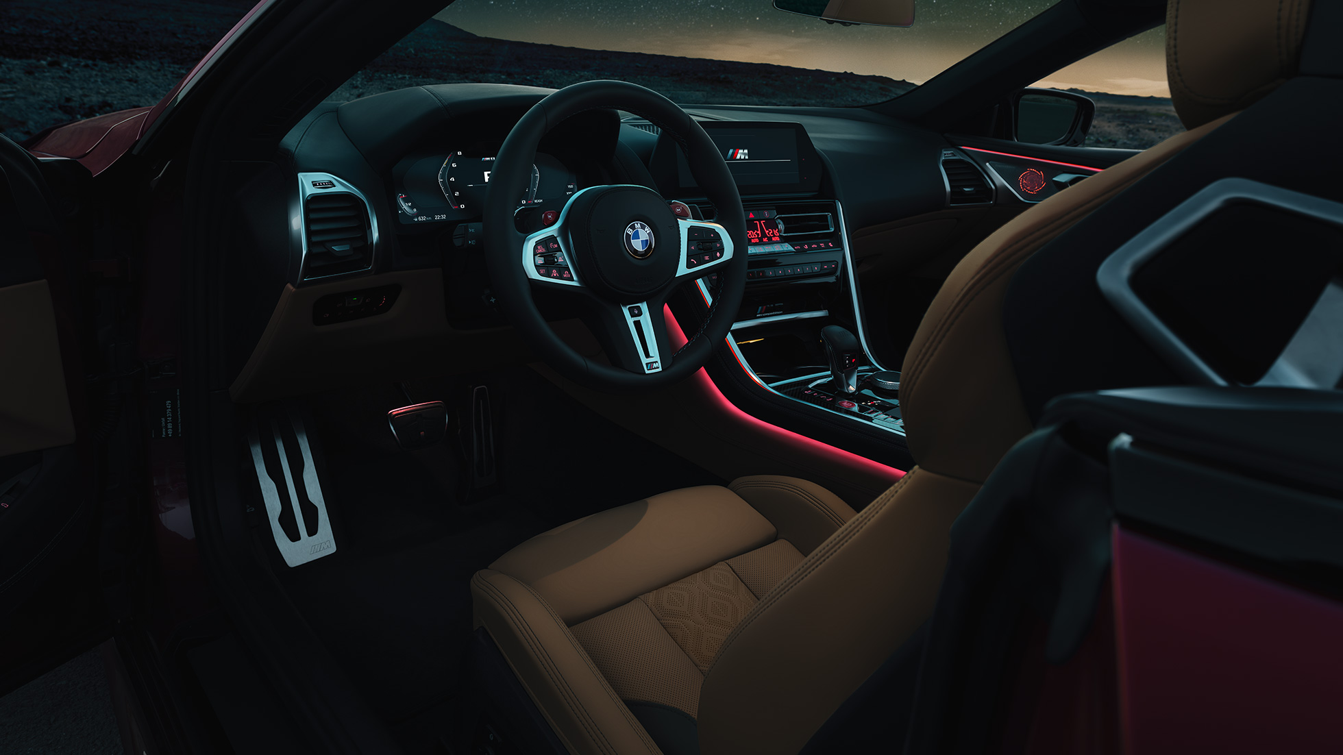 BMW M8 Competition Cabrio, poste de conduite F91. BMW M8 Competition Cabrio, poste de conduite de nuit avec volant M en cuir et éclairage d’ambiance rouge F91.