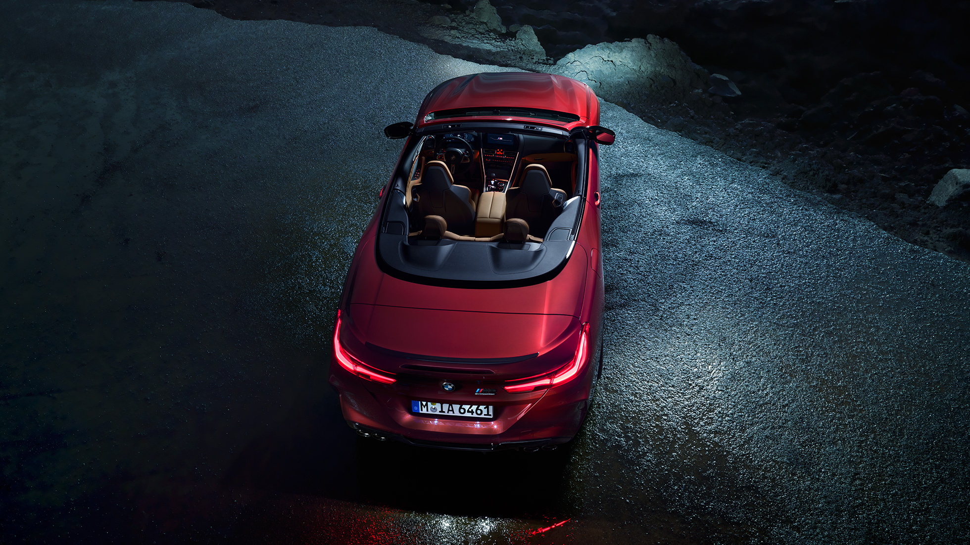 BMW M8 Competition Cabrio, vue en plongée F91. BMW M8 Competition Cabrio en Motegi Rot metallic avec capote ouverte, à l’arrêt sur l’asphalte, vue en plongée nocturne F91.