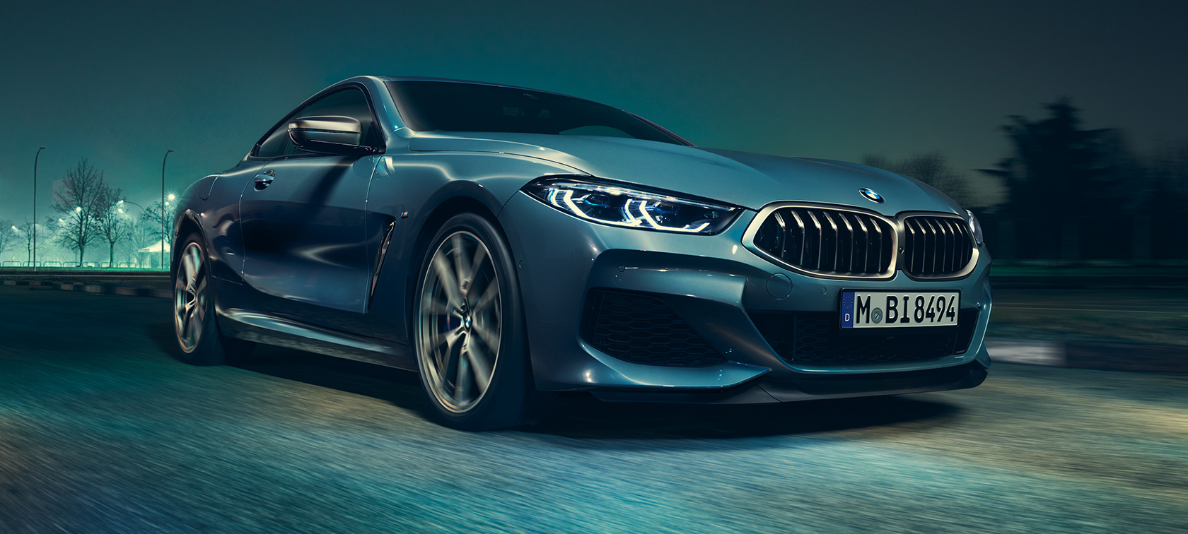 BMW M850i xDrive Coupé, driekwart vooraanzicht G15. BMW M850i xDrive Coupé in Barcelona Blau metallic in beweging, driekwart vooraanzicht G15.