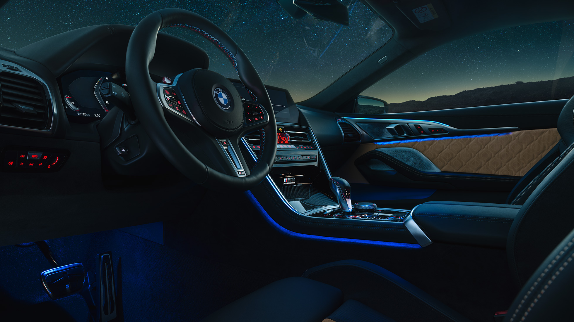 BMW M8 Competition Coupé, cockpit F92. BMW M8 Competition Cabrio, cockpit ‘s nachts met lederen M stuur en blauwe sfeerverlichting F92.