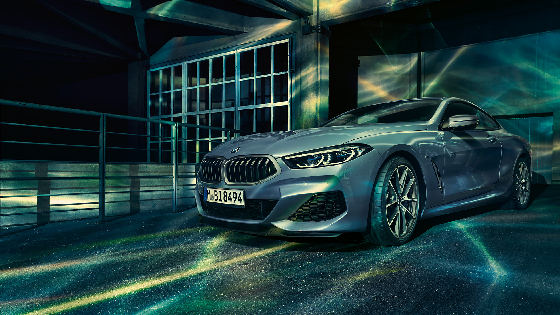 BMW M850i xDrive Coupé, driekwart vooraanzicht G15. BMW M850i xDrive Coupé in Barcelona Blau metallic, driekwart vooraanzicht stilstaand voor gebouw G15.