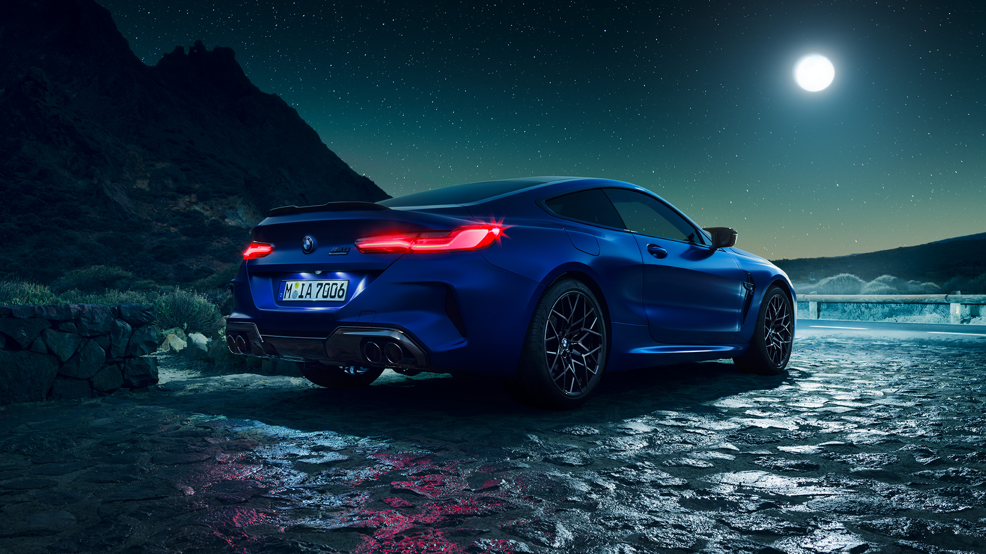 BMW M8 Competition Coupé, driekwart achteraanzicht F92. BMW M8 Competition Coupé in Marina Bay Blau metallic brandende LED-achterlichten, stilstaand driekwart achteraanzicht bij volle maan F92.