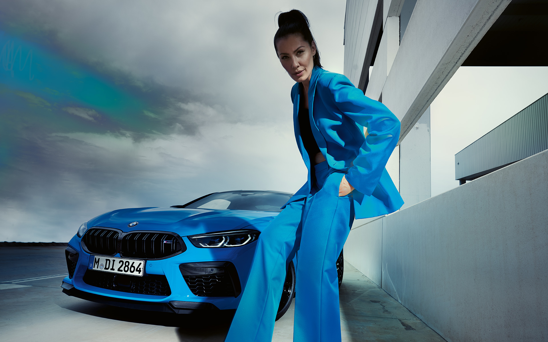 BMW M8 Competition Coupé F92 LCI 2022 driekwart vooraanzicht BMW M8 Competition Coupé F92 LCI facelift 2022 Daytona Beach Blau uni driekwart vooraanzicht met vrouwelijk model in blauw broekpak