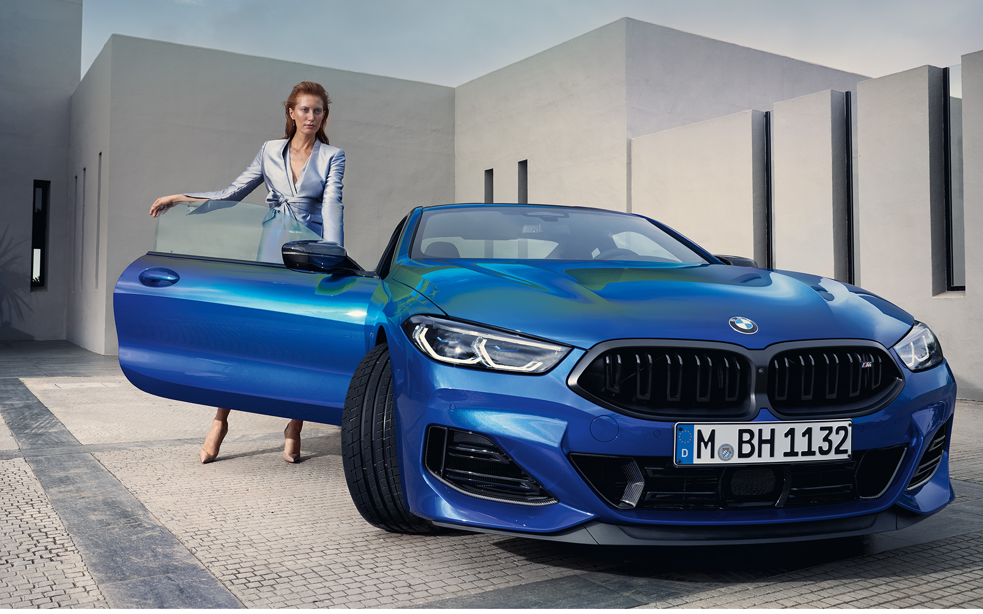 BMW M850i xDrive Coupé G15 LCI facelift 2022 vooraanzicht BMW M850i xDrive Coupé G15 LCI facelift 2022 M Portimao Blau metallic vooraanzicht stilstaand met vrouwelijk model in geopende passagiersdeur