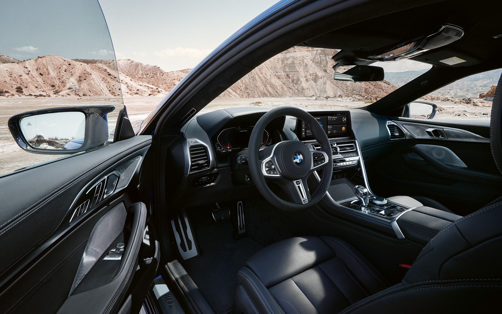 BMW M850i xDrive Coupé G15 LCI facelift 2022 op de bestuurder georiënteerde cockpit met lederen M stuur BMW M850i xDrive Coupé G15 LCI facelift 2022 op de bestuurder georiënteerde cockpit met lederen M stuur bij geopende bestuurdersdeur