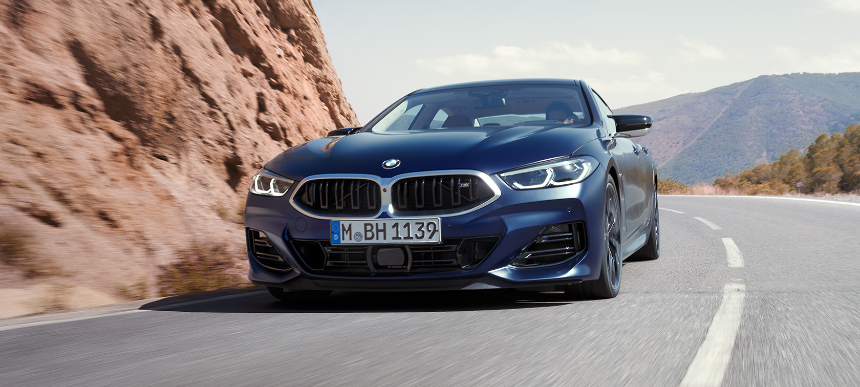 Driekwart vooraanzicht rijdend BMW M850i xDrive Gran Coupé G16 LCI facelift 2022 BMW M850i xDrive Gran Coupé G16 LCI facelift 2022 BMW Individual Frozen Tansanitblau metallic driekwart vooraanzicht rijdend in de bocht