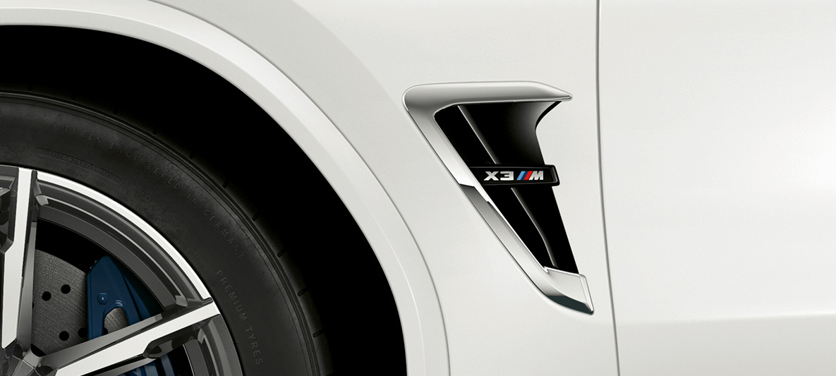 BMW X3 M, M kieuwen F97. BMW X3 M in Alpinweiß, exterieur, M kieuwen met chroomhighlights en modelbenaming F97.