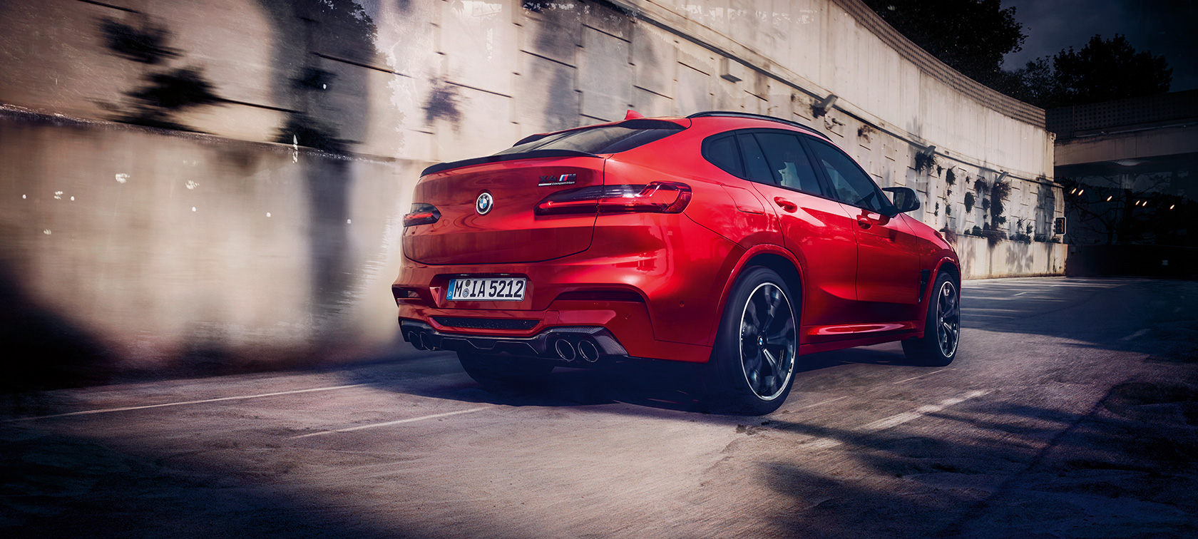 Extérieur de la BMW X4 M Competition, vue de trois quarts arrière F98. Extérieur de la BMW X4 M Competition en Toronto Rot metallic, en mouvement, vue de trois quarts arrière F98.