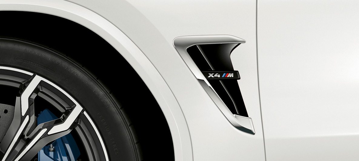 BMW X4 M, naseaux M F98. Extérieur de la BMW X4 M en Alpinweiß, avant, naseaux M avec accents chromés et insigne du modèle F98.