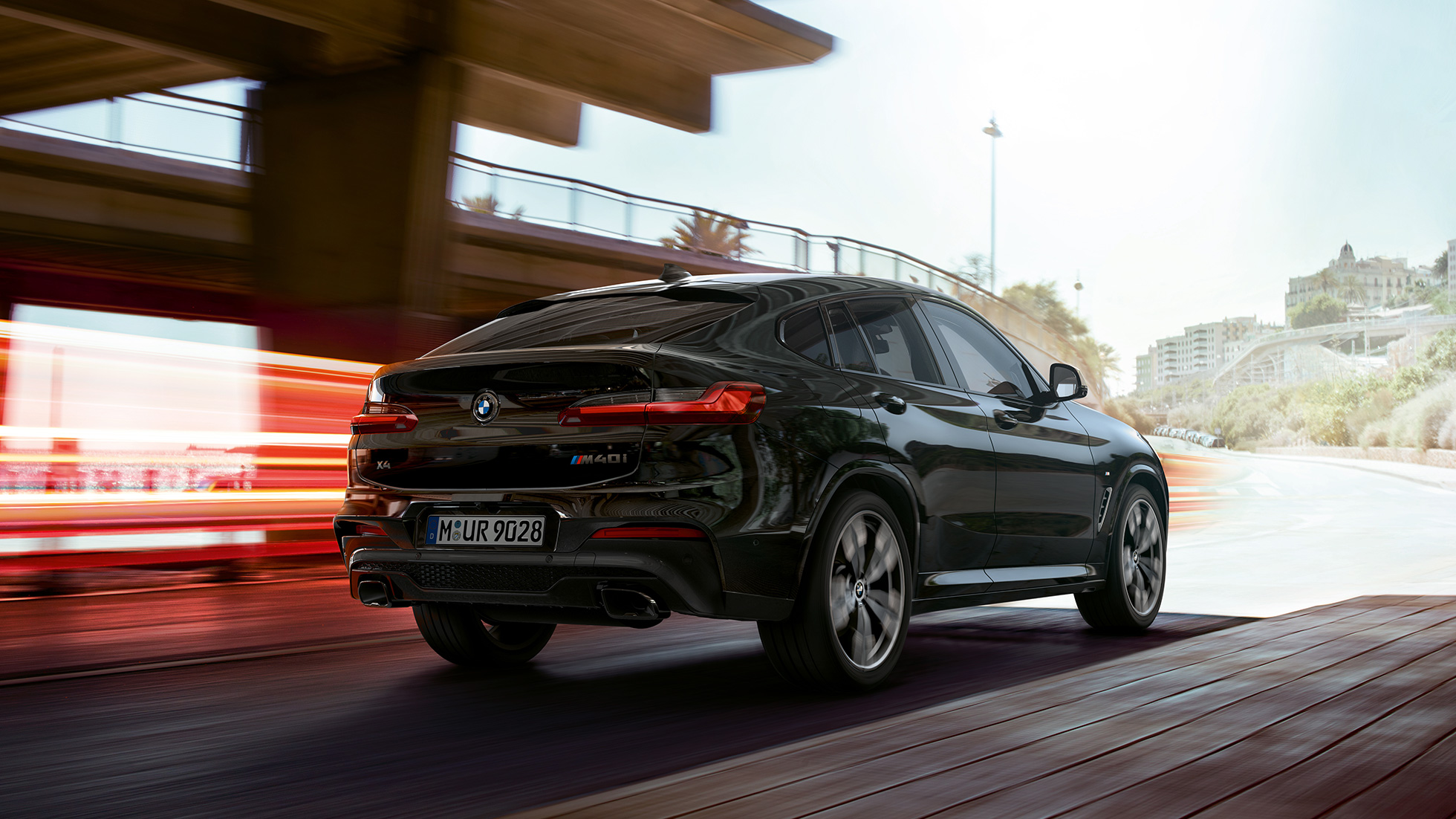 BMW X4 M40i, driekwart vooraanzicht G02. BMW X4 M40i in Saphirschwarz metallic, rijdend, exterieur, driekwart vooraanzicht met lichtstrepen G02.