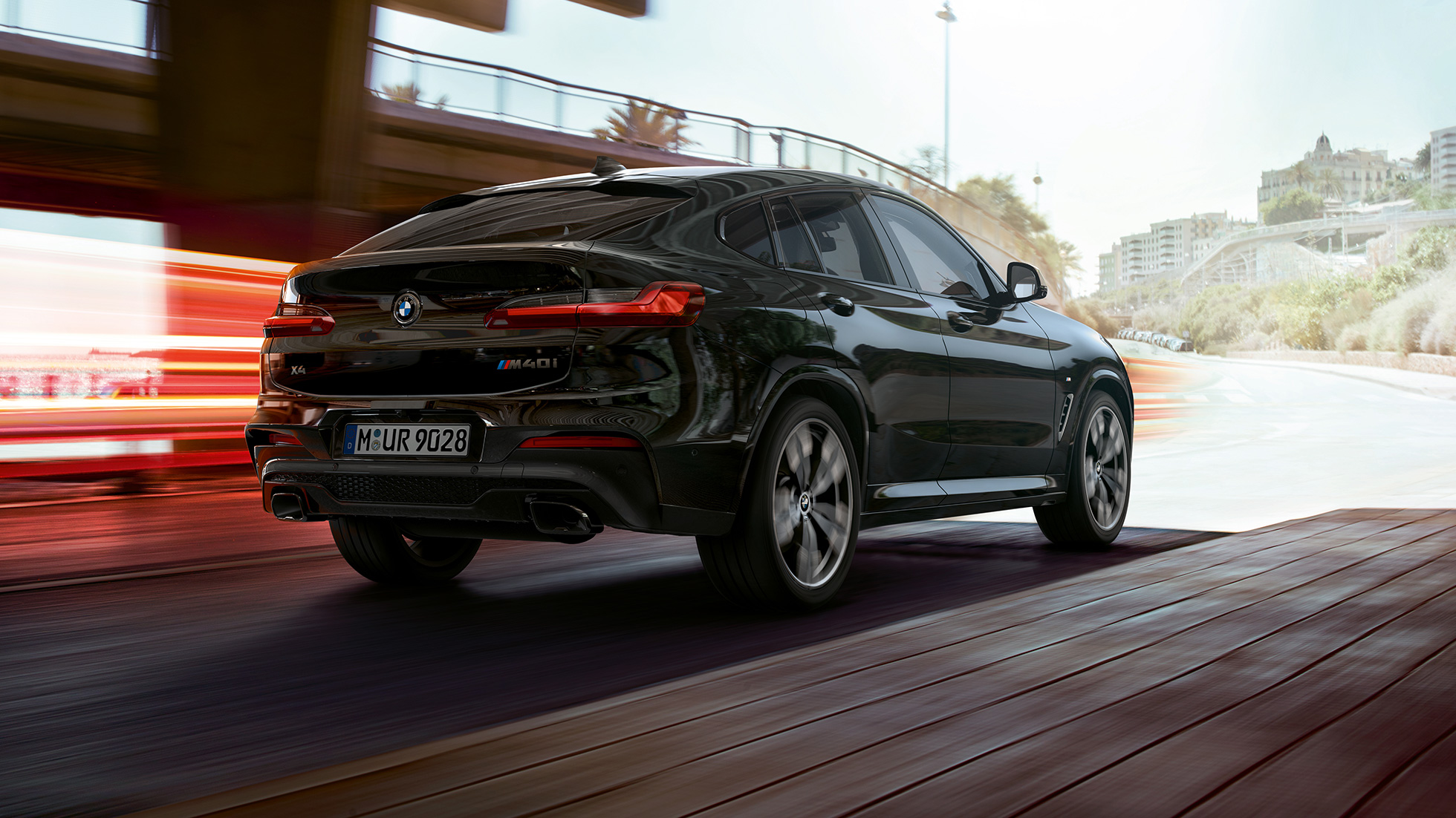 BMW X4 M40i, driekwart achteraanzicht G02. BMW X4 M40i in Saphirschwarz metallic, exterieur, driekwart achteraanzicht rechts met lichtstrepen G02.
