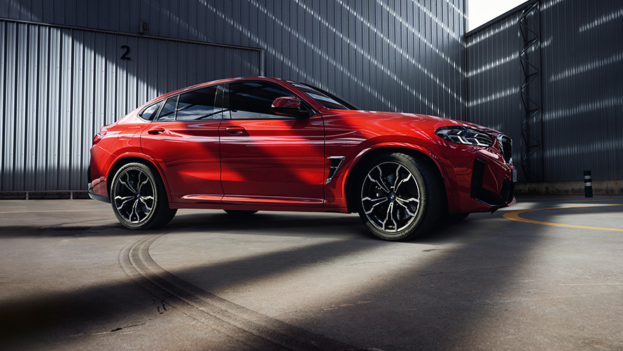 MW X4 M F98 LCI Facelift 2021 Toronto Rot metallic vue de profil devant un bâtiment d'usine