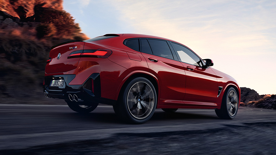 BMW X4 M F98 LCI Facelift 2021 Toronto Rot metallic vue de trois quarts arrière roulant sur la route