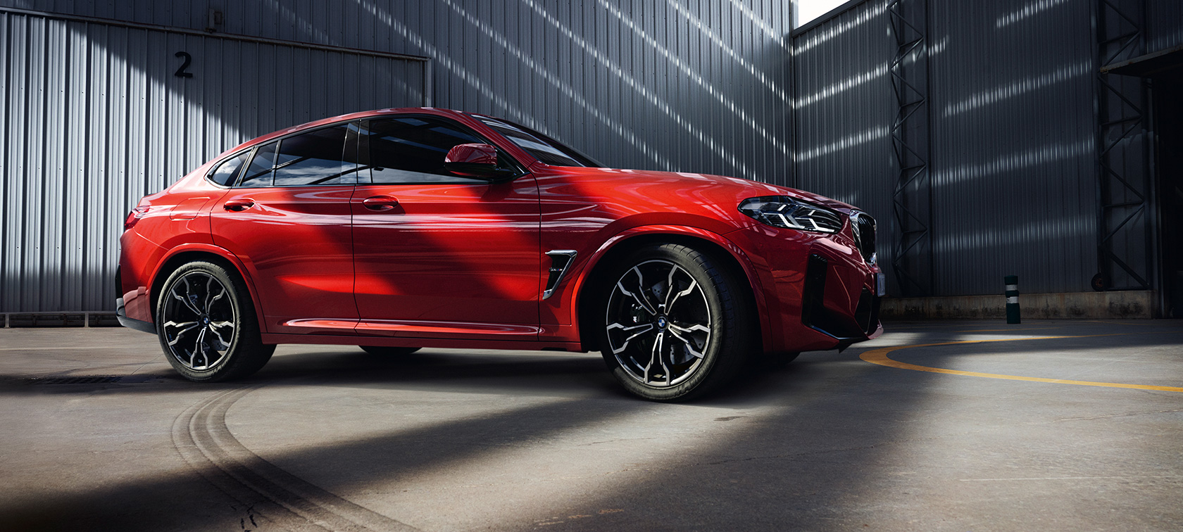 Driekwart vooraanzicht BMW X4 M F98 LCI facelift 2021 BMW X4 M F98 LCI facelift 2021 Toronto Rot metallic driekwart vooraanzicht in fabriekshal