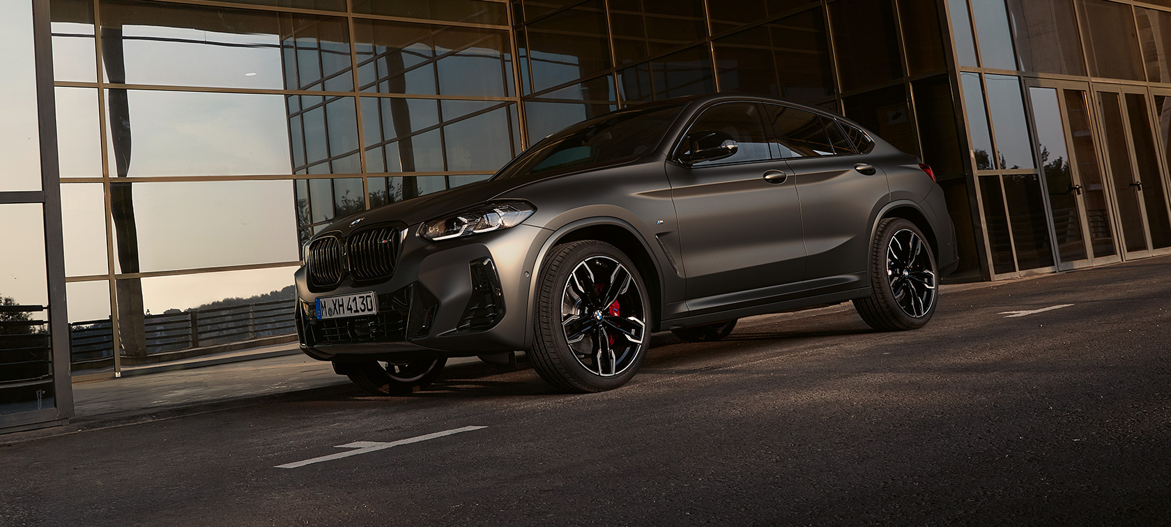 Driekwart vooraanzicht BMW X4 M40i G02 LCI 2021 facelift BMW X4 M40i G02 LCI 2021 facelift driekwart vooraanzicht voor glazen gevel