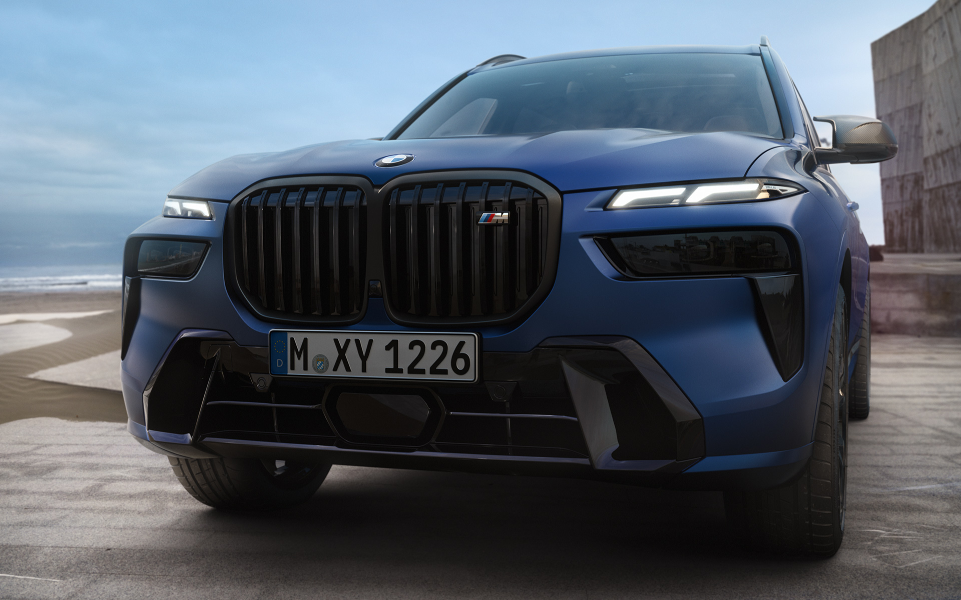 Partie avant BMW X7 M60i xDrive G07 LCI Frozen Marina Bay Blue en stationnement gros plan Partie avant BMW X7 M60i xDrive G07 LCI Frozen Marina Bay Blue en stationnement gros plan