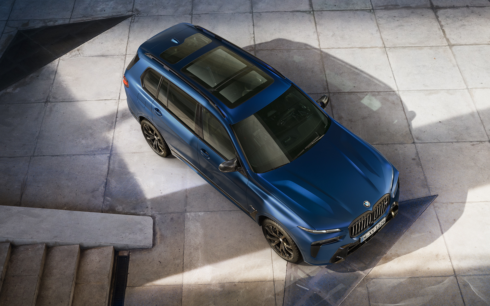 BMW X7 M60i xDrive G07 LCI Frozen Marina Bay Blue en stationnement perspective aérienne BMW X7 M60i xDrive G07 LCI Frozen Marina Bay Blue en stationnement perspective aérienne