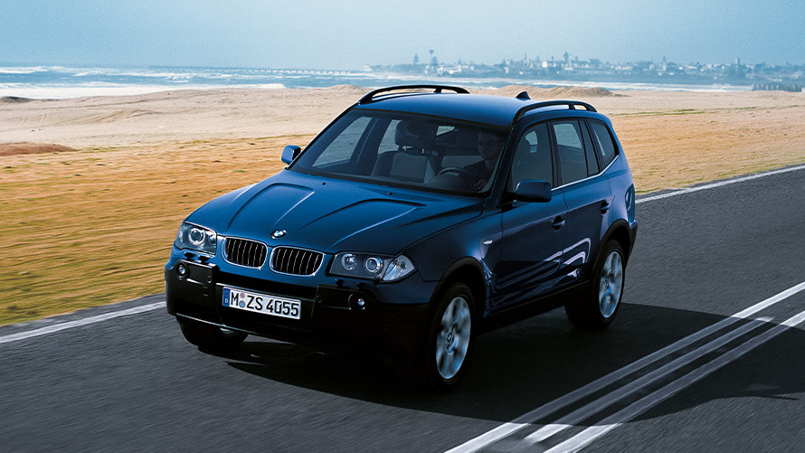 BMW X3 E83 eerste generatie driekwart vooraanzicht rijdend op de weg BMW X-modellen BMW X3 E83 eerste generatie driekwart vooraanzicht rijdend op de weg