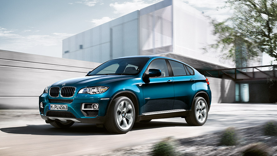 BMW X6 E71 eerste generatie driekwart zijaanzicht stilstaand voor gebouw BMW X-modellen BMW X6 E71 eerste generatie driekwart zijaanzicht stilstaand voor gebouw