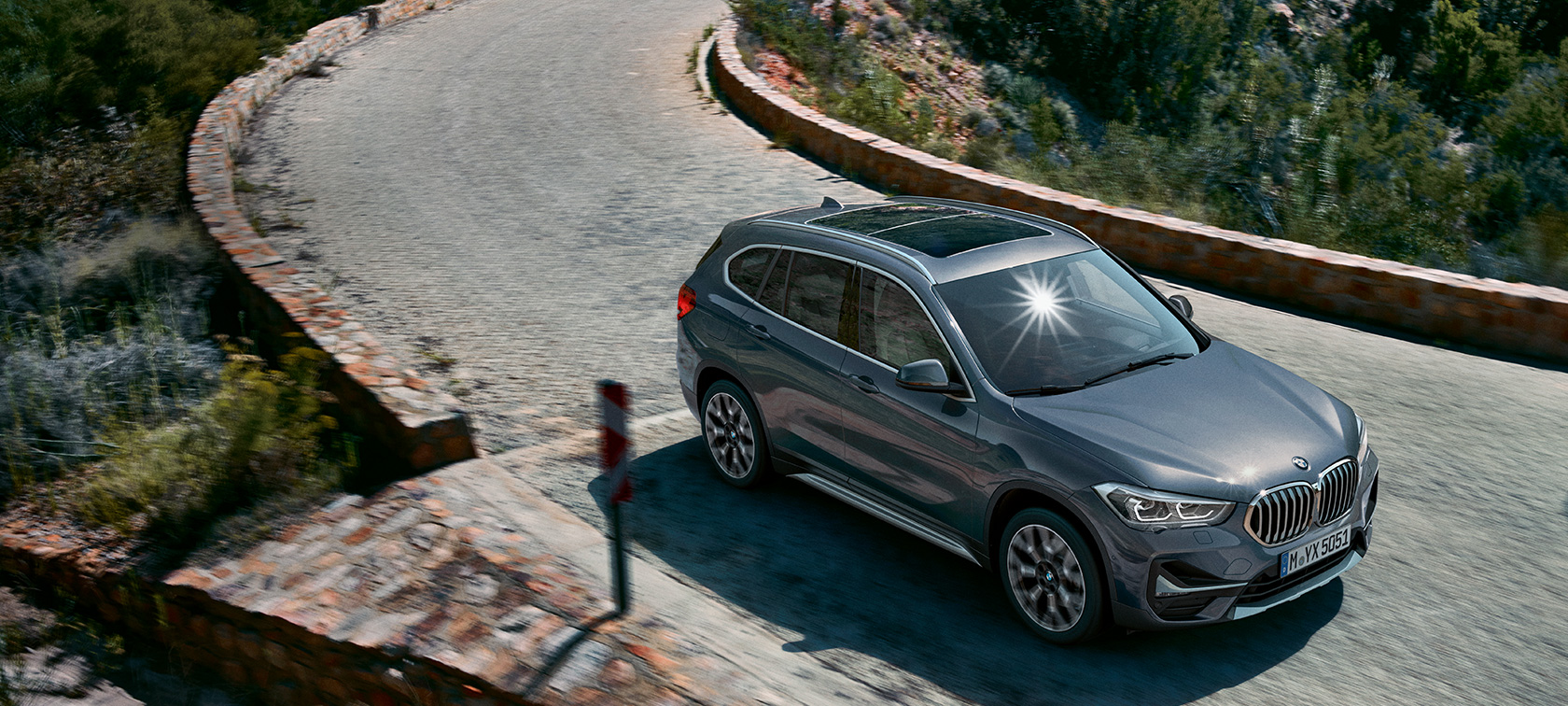BMW X1 vue de trois quarts avant. F48 BMW X1, vue de trois quarts avant devant un paysage de montagnes. F48
