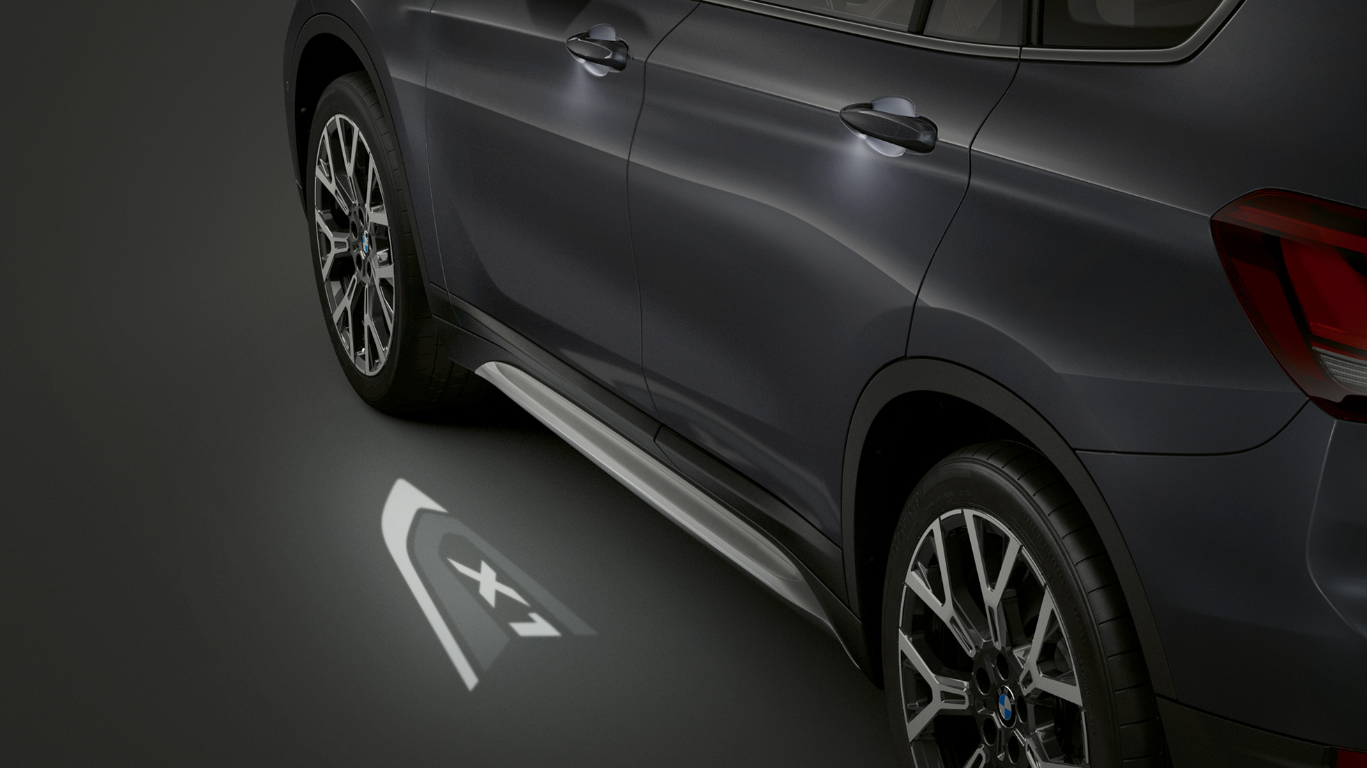 BMW X1, LED-projectie “X1” F48. BMW X1, zijaanzicht met zicht op de LED-projectie “X1” F48.