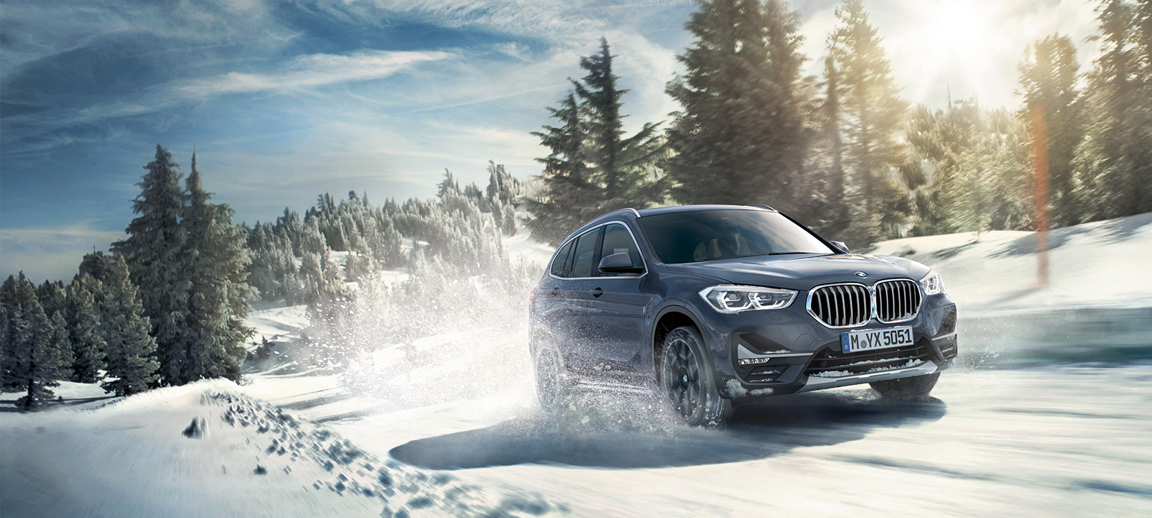 BMW X1 xDrive20i F48 LCI in BMW Individual Storm Bay metallic, rijdend in winterlandschap BMW X1 xDrive20i F48 LCI in BMW Individual Storm Bay metallic, rijdend in winterlandschap