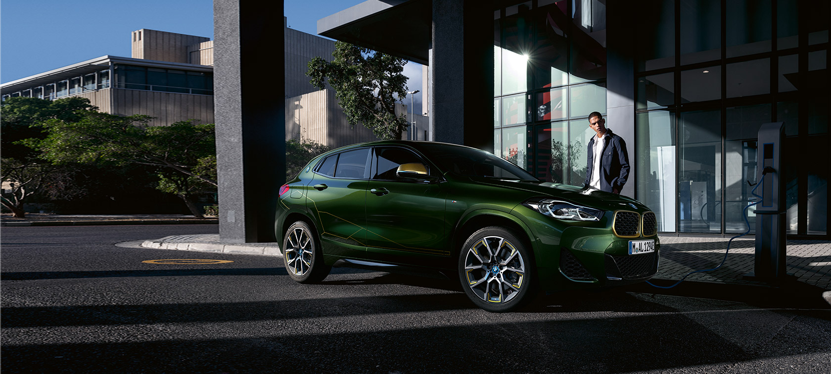 BMW X2 F39 Sanremo Green metallic driekwart zijaanzicht met model BMW X2 F39 Sanremo Green metallic driekwart zijaanzicht met model
