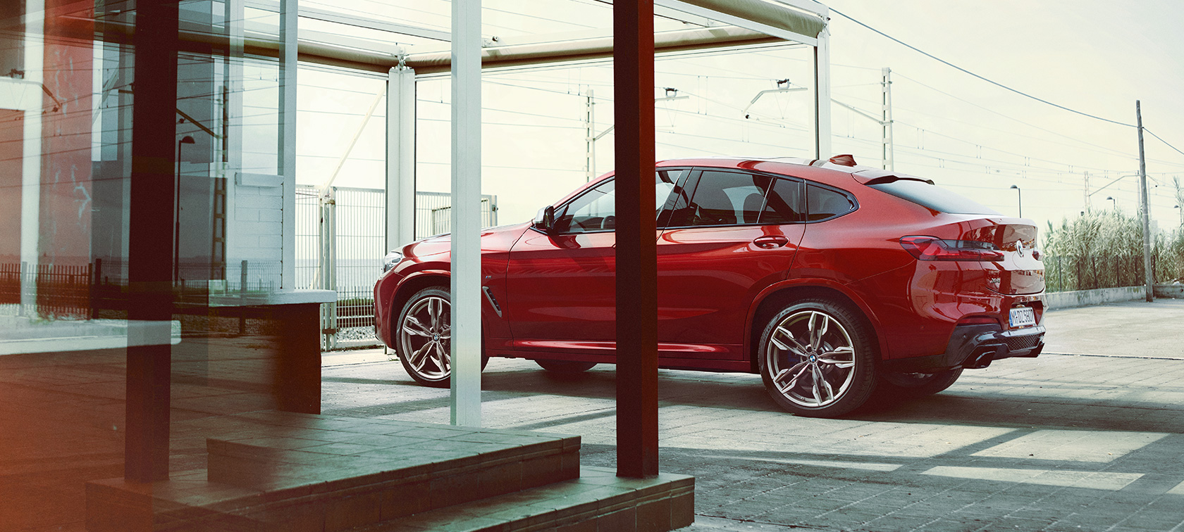 Vue de profil de la BMW X4 G02 BMW X4 M40i G02 2018 en Flamencorot Brillanteffekt, vue de profil en stationnement