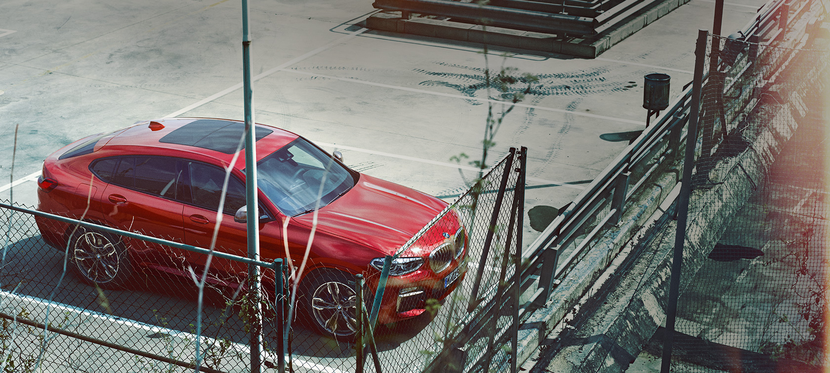 BMW X4 parkerend BMW X4 G02 2018 Flamencorot Brillanteffekt parkerend op parkeerdek vogelperspectief