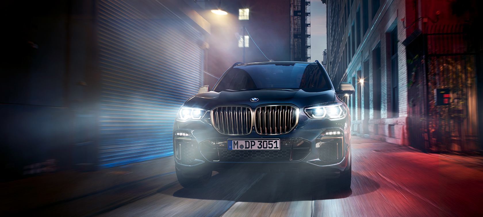 BMW X5 M50d in actie De BMW X5 M50d op een nachtelijke straat in de stad