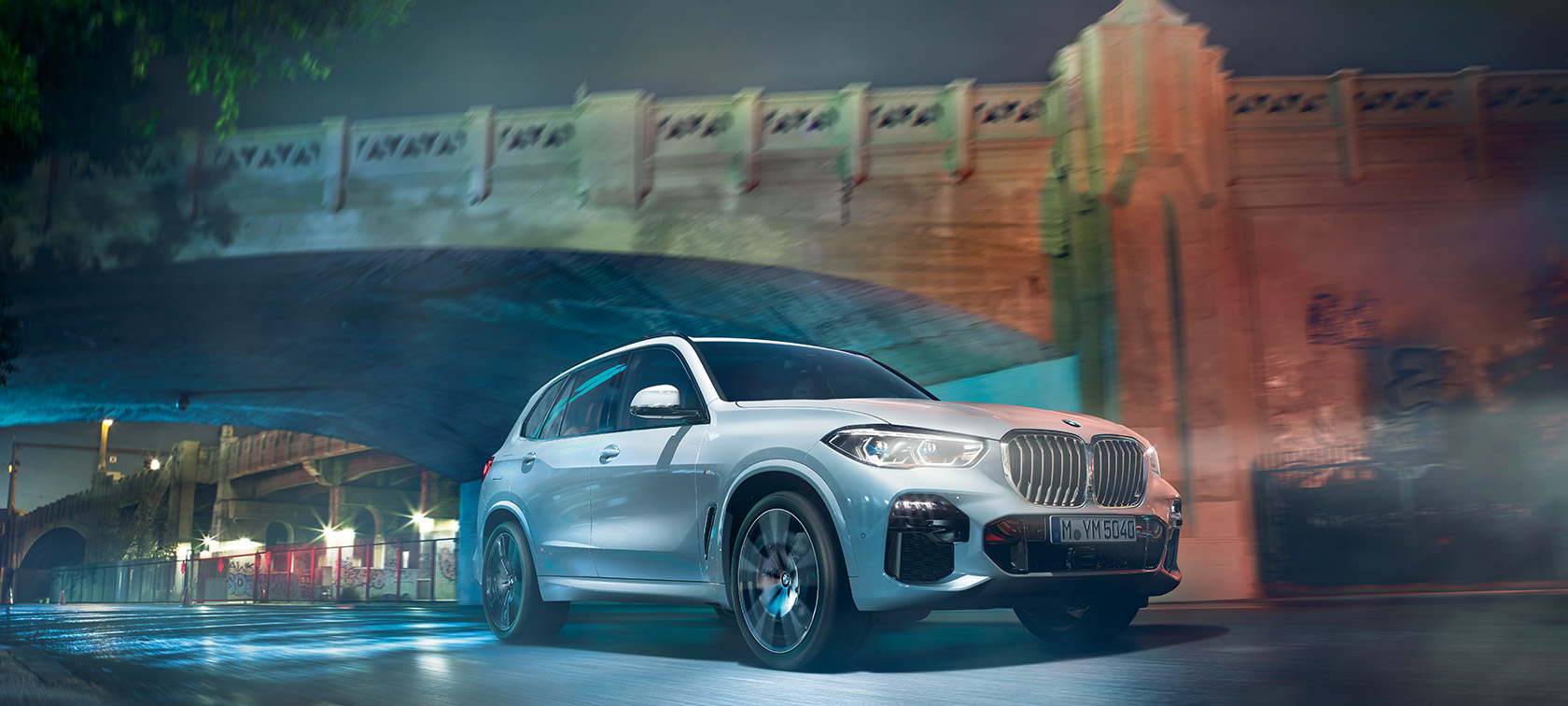 BMW X5 SUV driekwart vooraanzicht BMW X5 SUV G05 2018 Mineralweiß metallic driekwart vooraanzicht in beweging ’s nachts