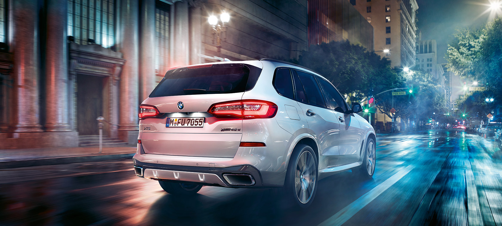 BMW X5 driekwart achteraanzicht rijdend BMW X5 G05 2021 Mineralweiß metallic driekwart achteraanzicht rijdend
