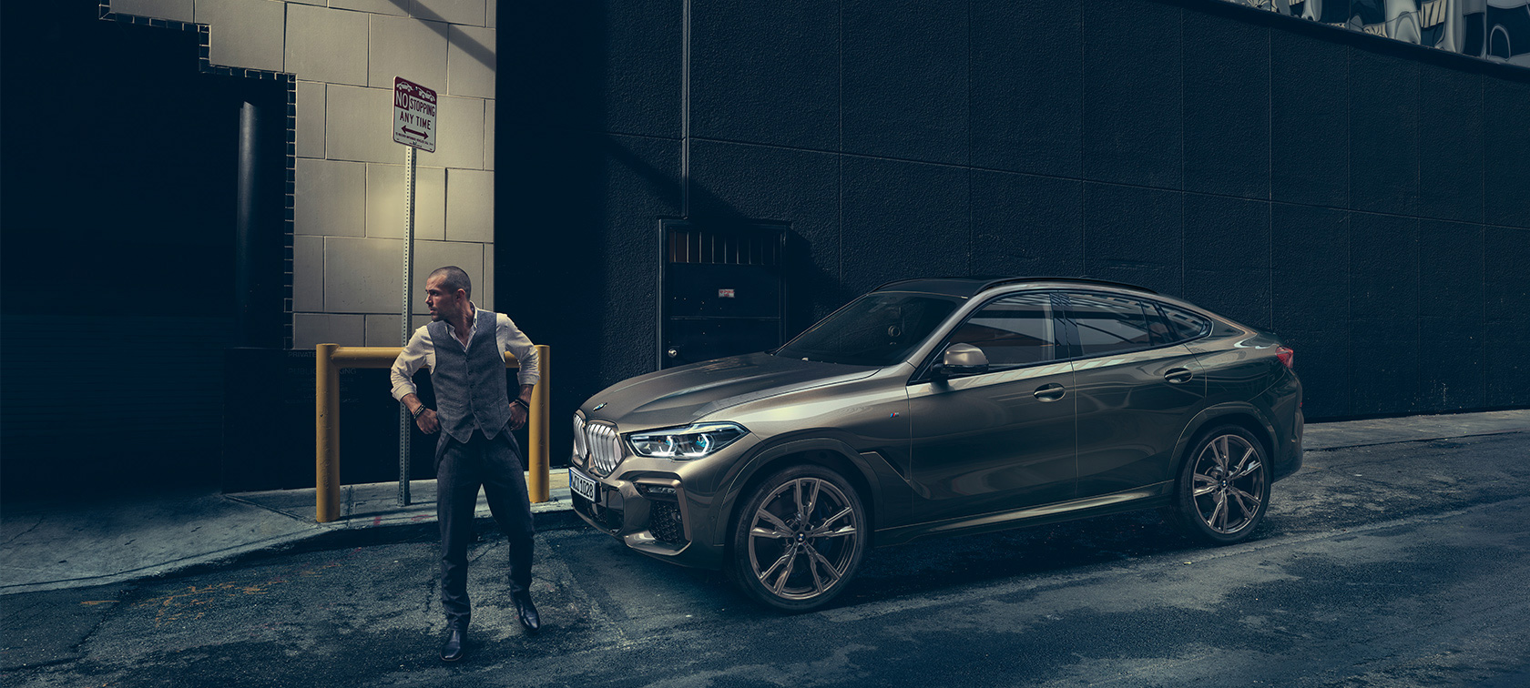 BMW X6 G06. BMW X6 in lateral perspective in front of an urban setting G06.