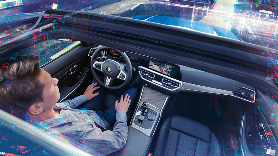 BMW Personal CoPilot : stationnement intelligent Un homme est assis dans une BMW stationnée et utilise l'assistant de stationnement de BMW Personal CoPilot.