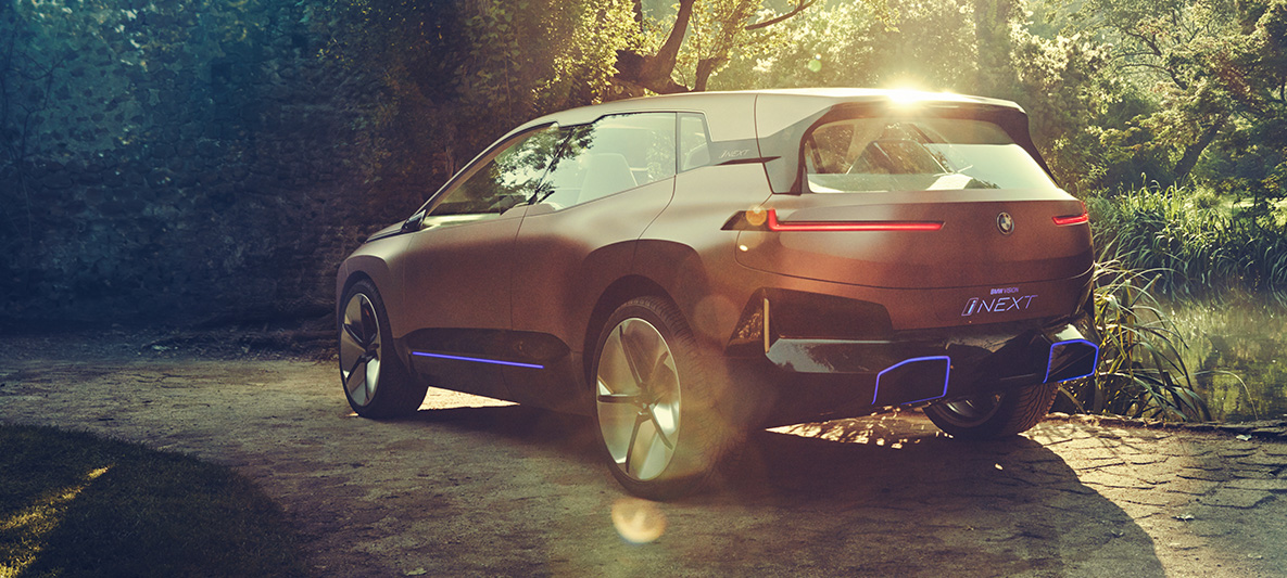Achteraanzicht van de BMW Vision iNEXT in de zon op een open plek Achteraanzicht van de BMW Vision iNEXT
