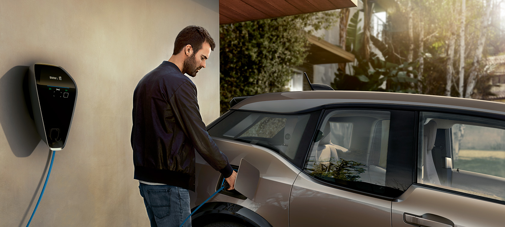 BMW i3s, homme devant une borne de recharge. Recharge BMW BMW i3s, homme devant une borne de recharge